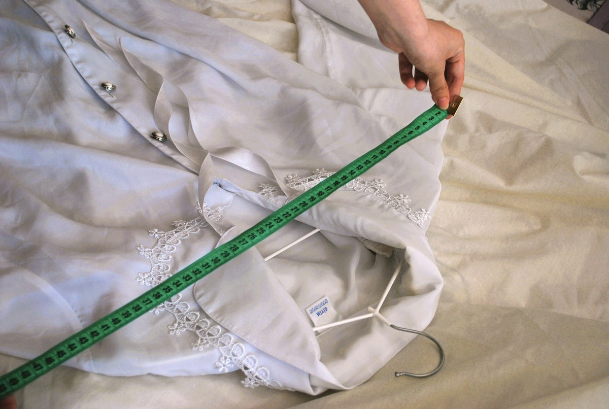 Tailor's measuring tape laid over a white shirt, for measuring underwear size